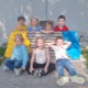 Kinder des absolvierten Kinderschwimmkurses sind auf einer Bank abgebildet.