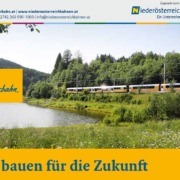 Niederösterreichbahn-Zug fährt durch eine grüne Landschaft mit See und Bäumen.